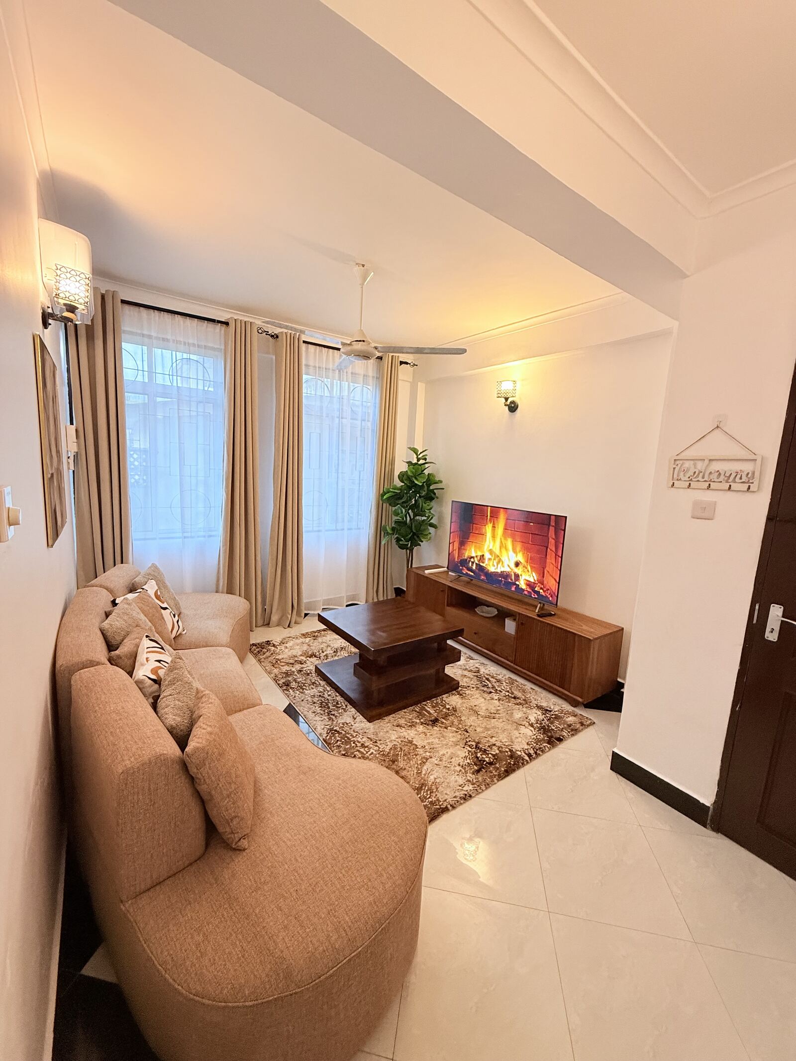 Mikocheni living room with curved sofa and smart TV