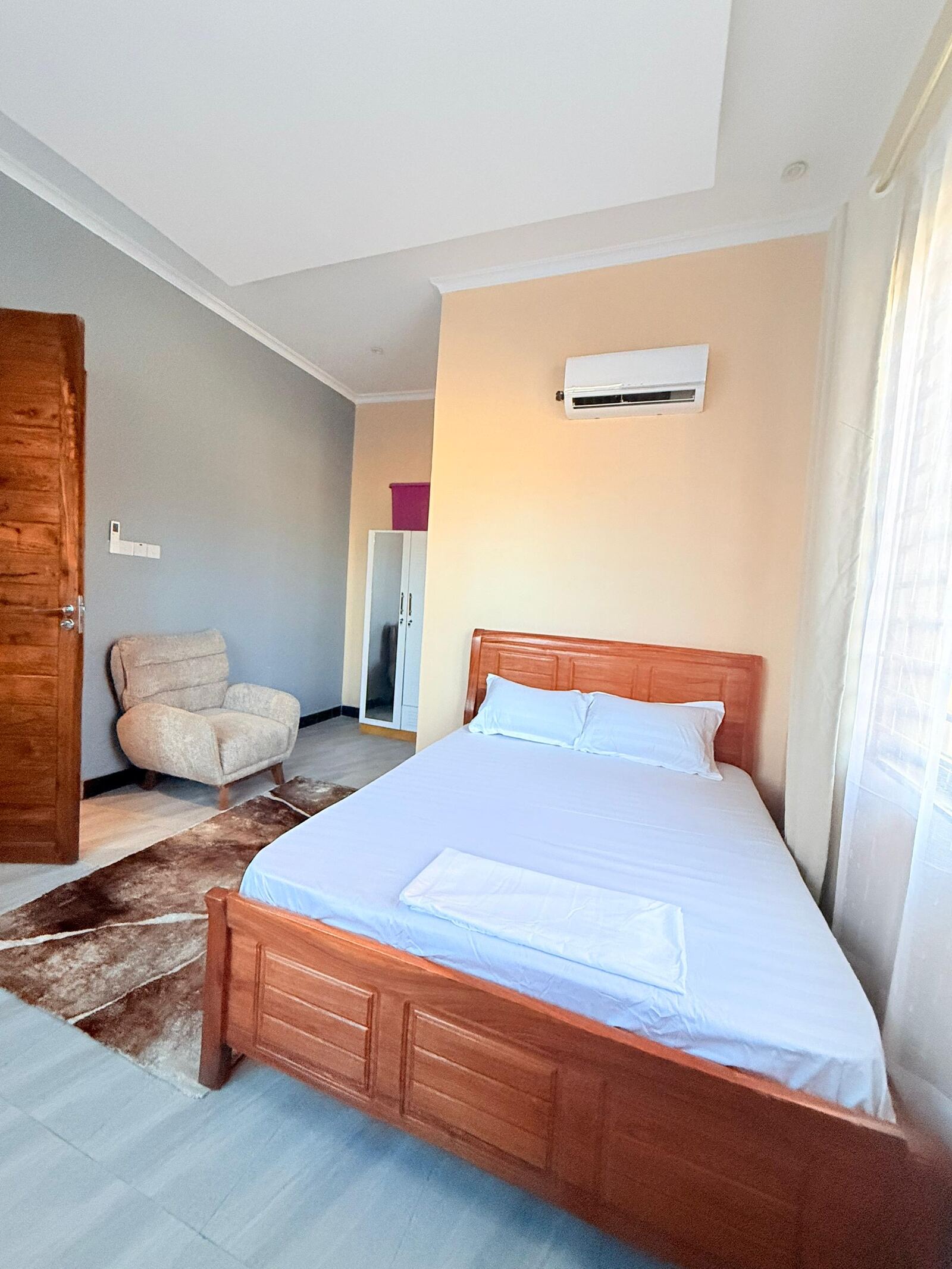 Sinza bedroom with wooden bed